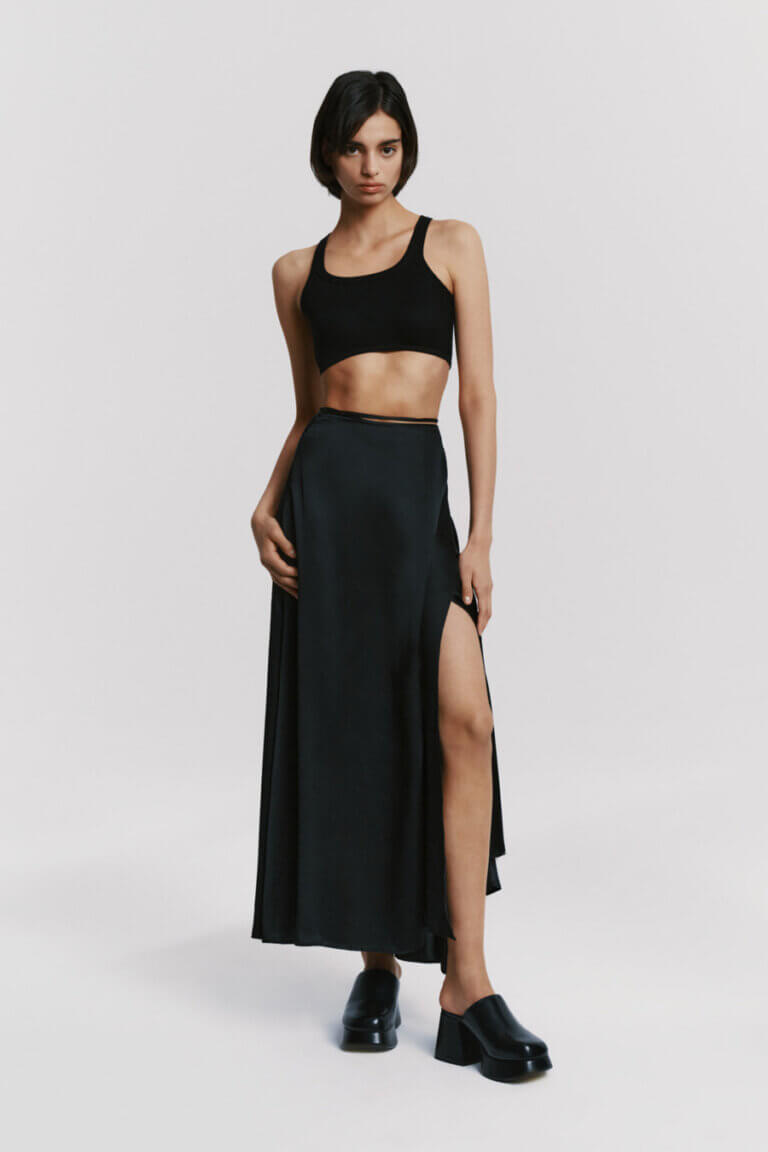 Model wearing Atthrea's black silk crop top and maxi wrap skirt, embodying sophistication.