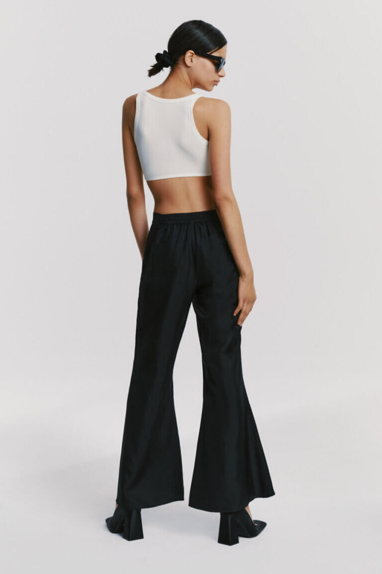 Back view of silk black trousers and white crop top, highlighting back details