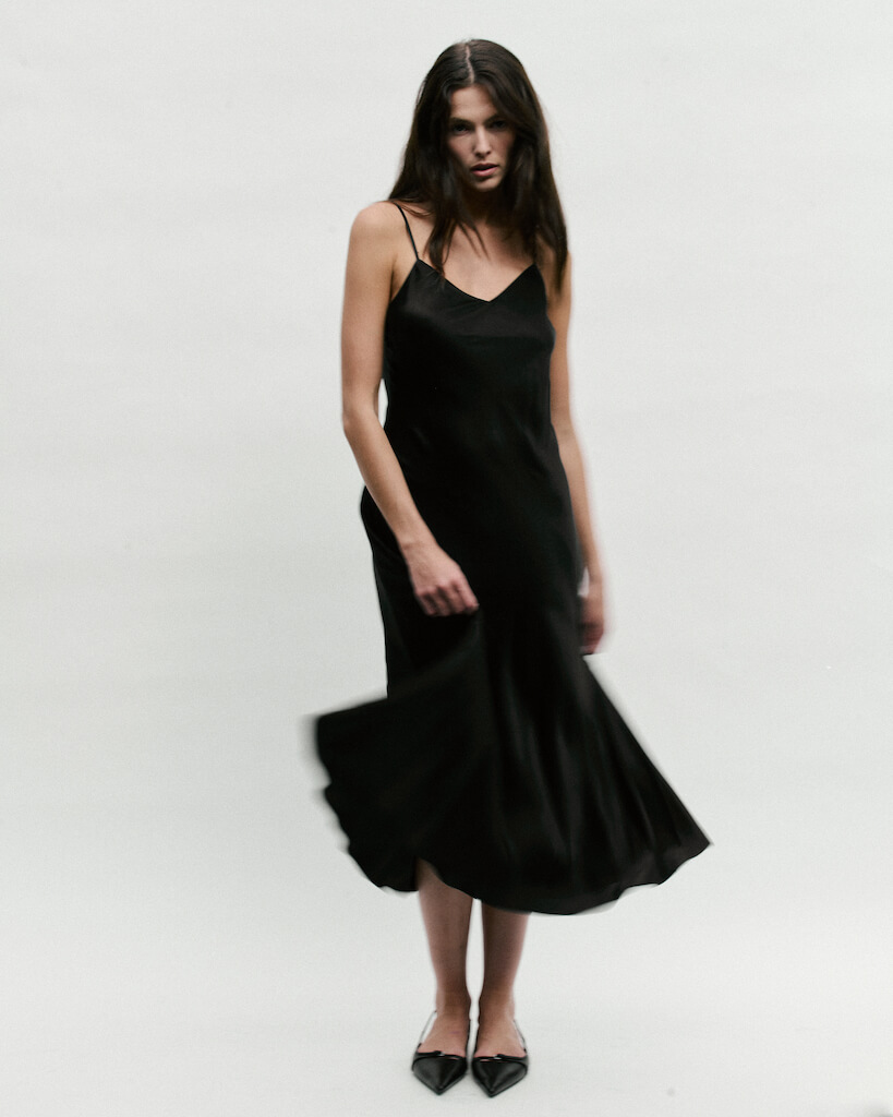 Model in a chic black silk maxi dress with a subtle sheen.